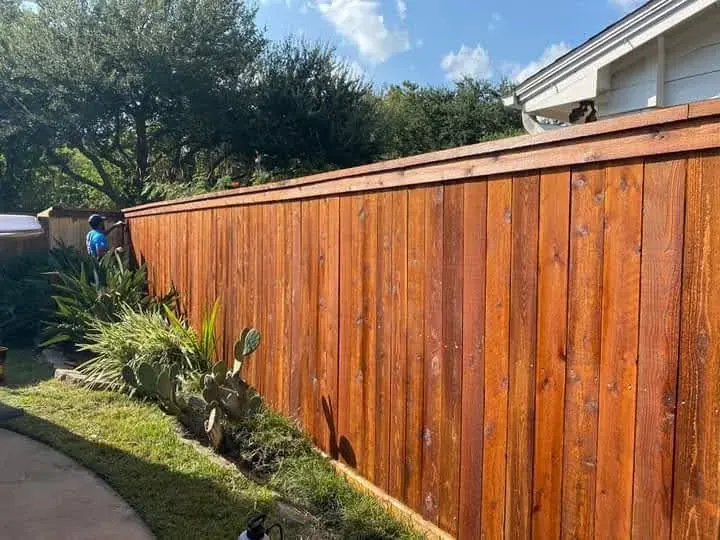 Stained cedar privacy fence with a red-brown finish