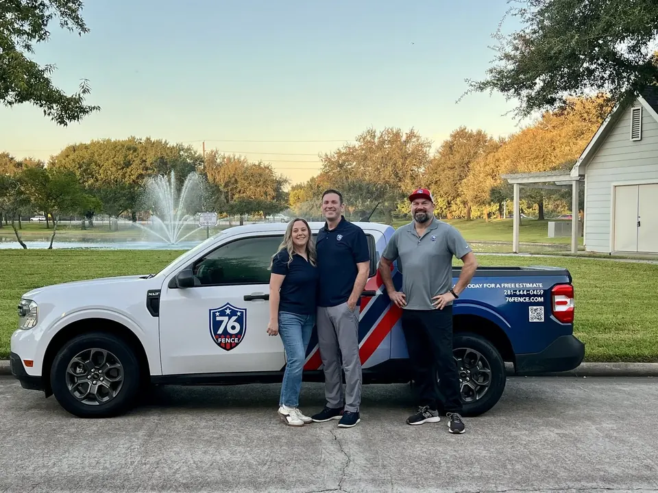 Three members of the 76 Fence team beside a 76 Fence work truck