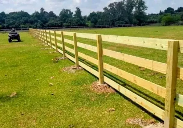 Three-rail wood pasture fence across an open field in Fulshear